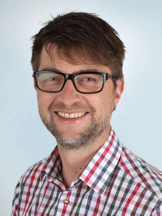 Portrait – Kompetenz trifft Persönlichkeit Portrait eines Mannes mit Brille und kariertem Hemd